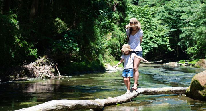 山の流れで遊ぶ母と子