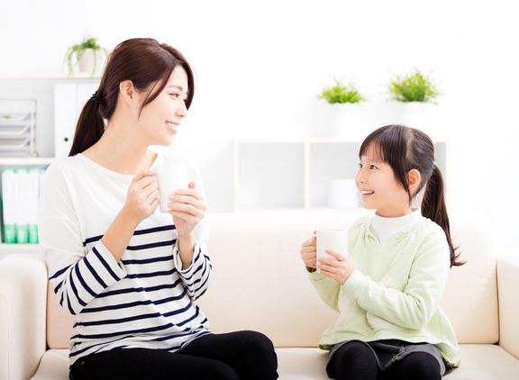 笑顔の母と娘のソファー