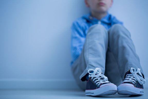悲しい少年が一人で座っています。