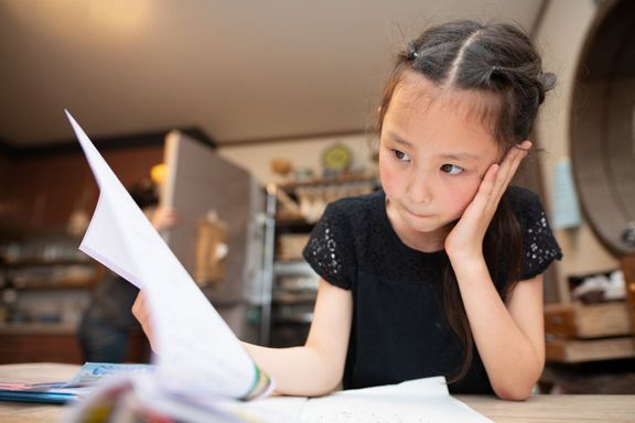 自宅で台所で勉強している女の子