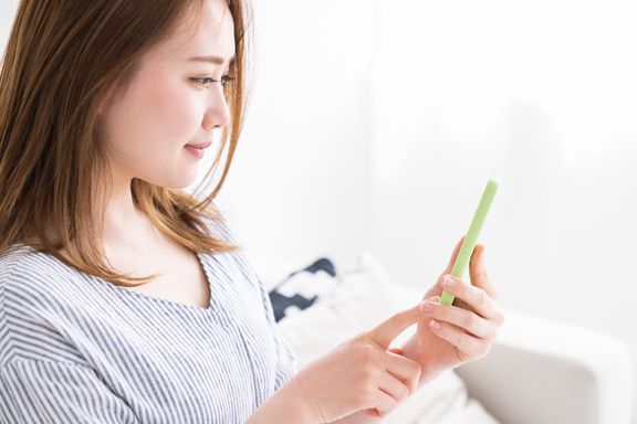 スマートフォンを見るためにアジアの女性