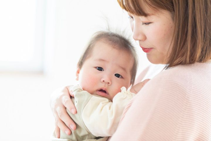 明るい部屋で赤ちゃんを抱くママ