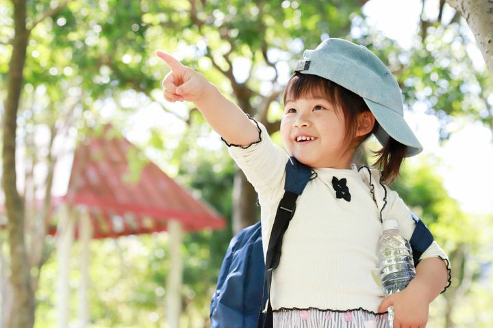 屋外で楽しむバックパックを持つ女の子