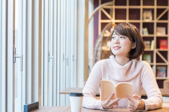 カフェで本を読んでいる女