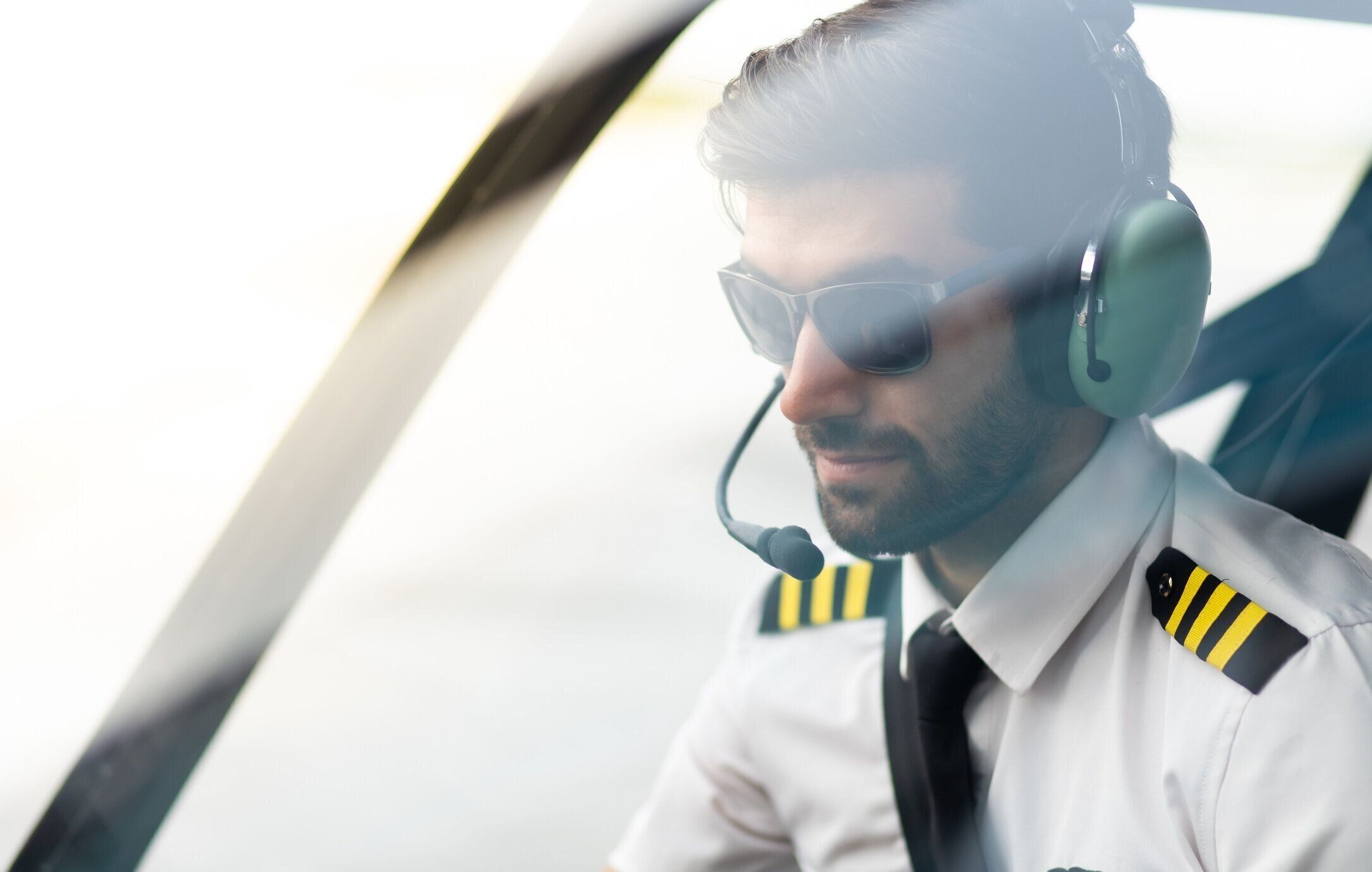 ヘリコプターの中に座っている制服を着た商業パイロットの肖像画