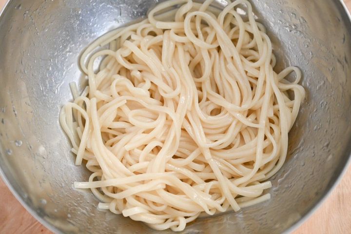 ボウルに入った調味油を絡めた麺