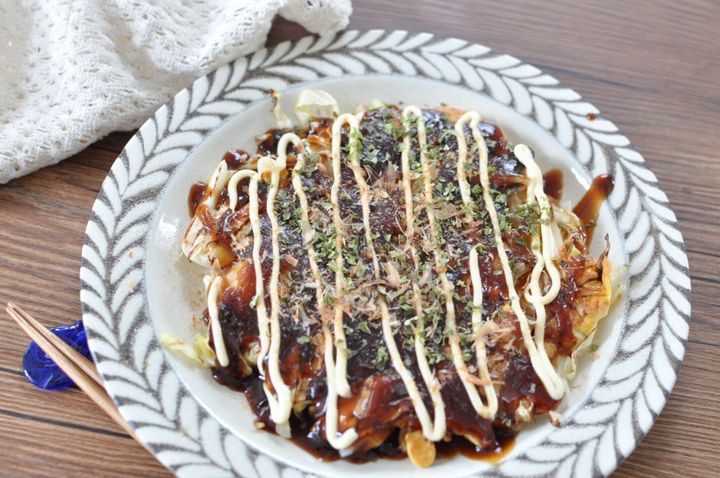 餅お好み焼きにトッピングをして盛り付けた様子