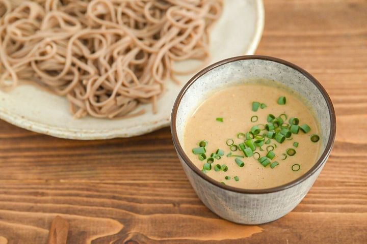 器に入ったねりごま豆腐だれと添えられたざるそば