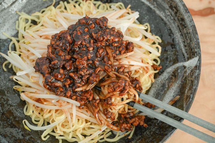 箸で混ぜている黒麻婆焼きそば