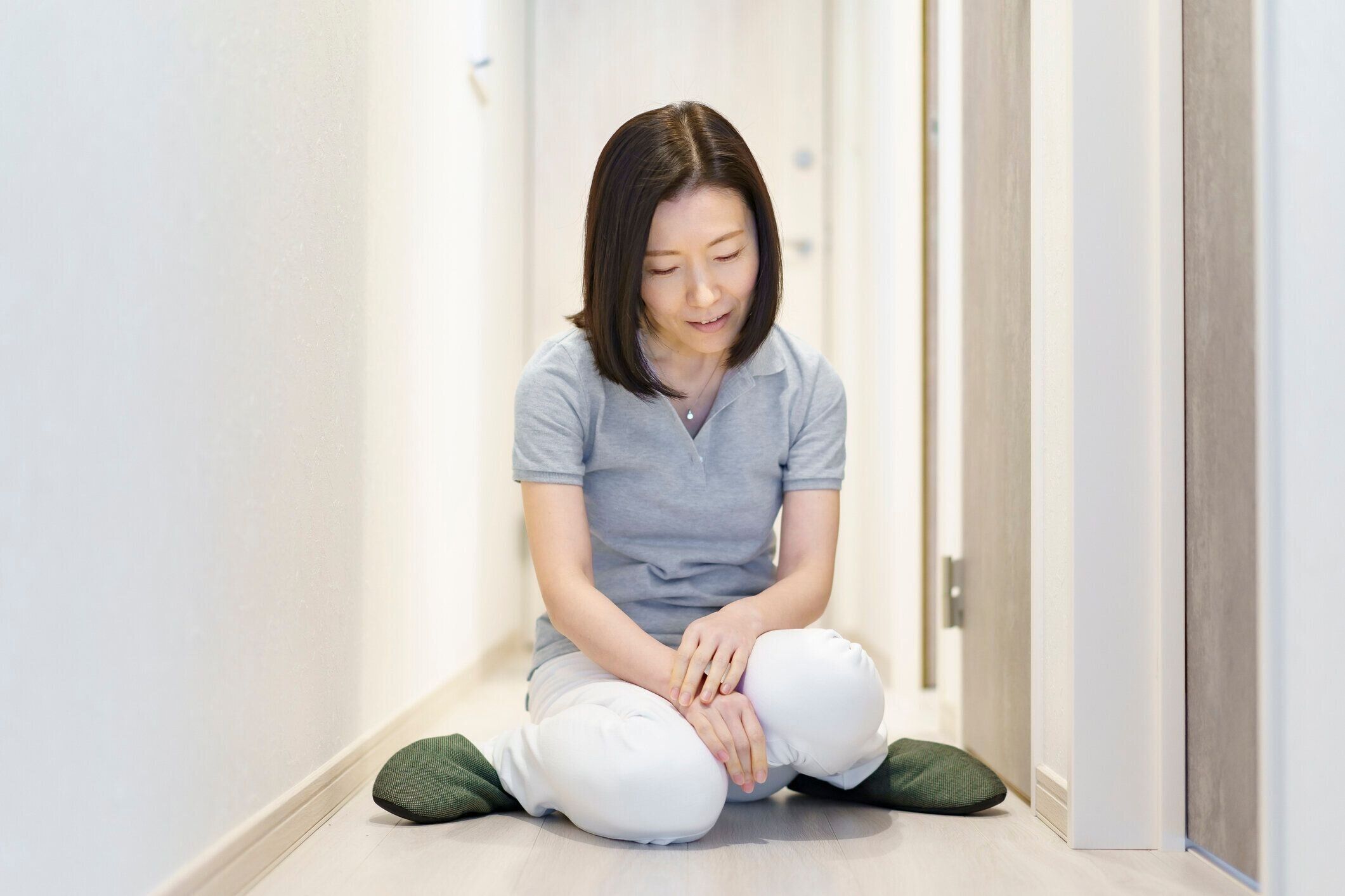 廊下に座っている中年女性