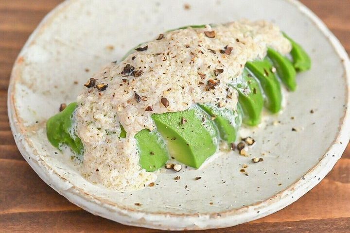 陶器の皿に盛られたアボカドのアンチョビソースがけ