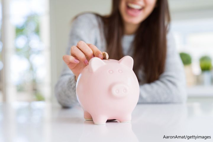 豚の貯金箱にお金を入れる