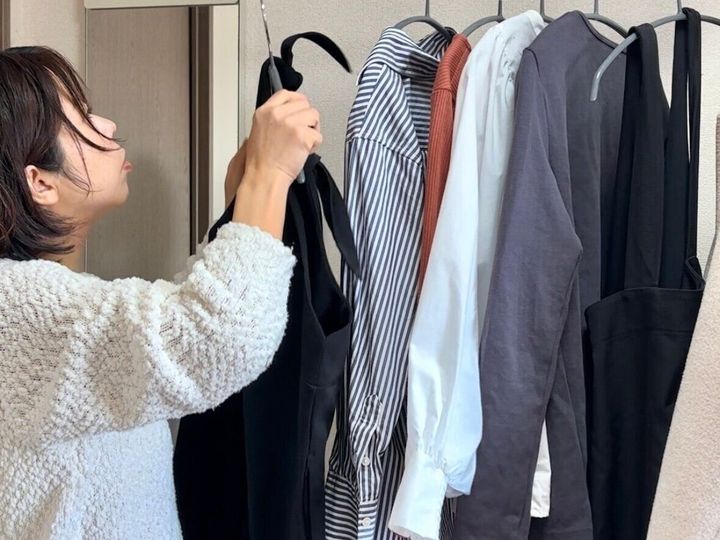 クローゼットに服をかける女性
