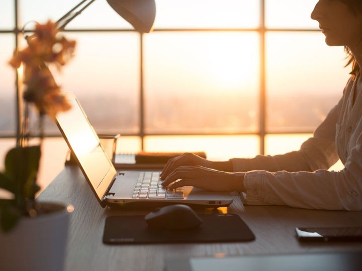 側女性プログラマー、ラップトップを使用して作業、入力、職場でインターネットをサーフィンの写真を見る。