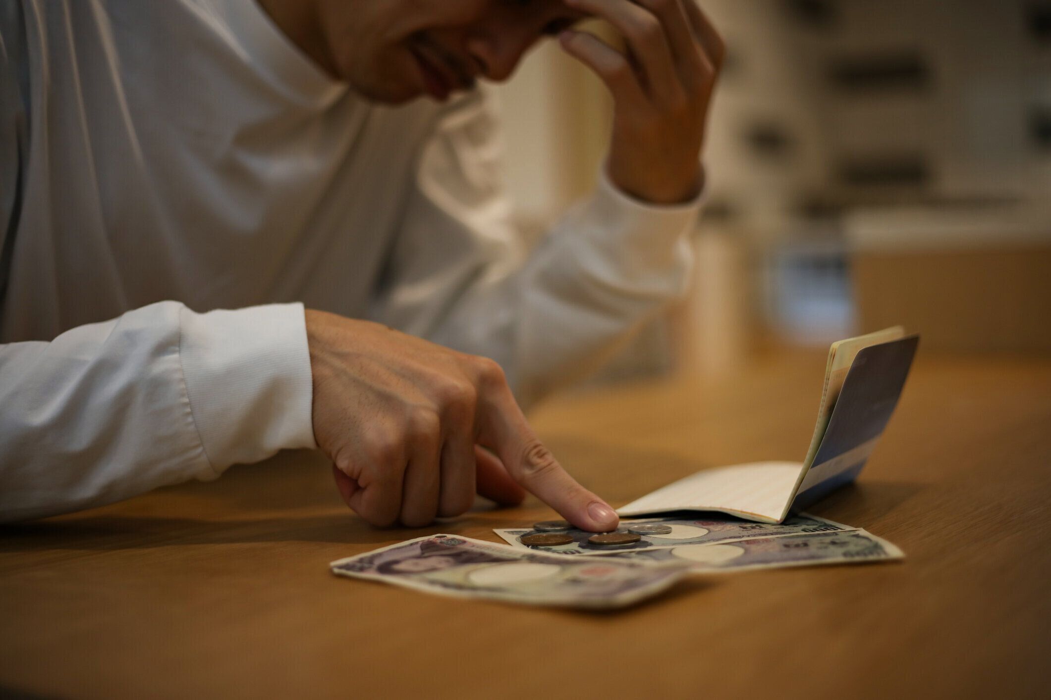 通帳を見ながら心配している男