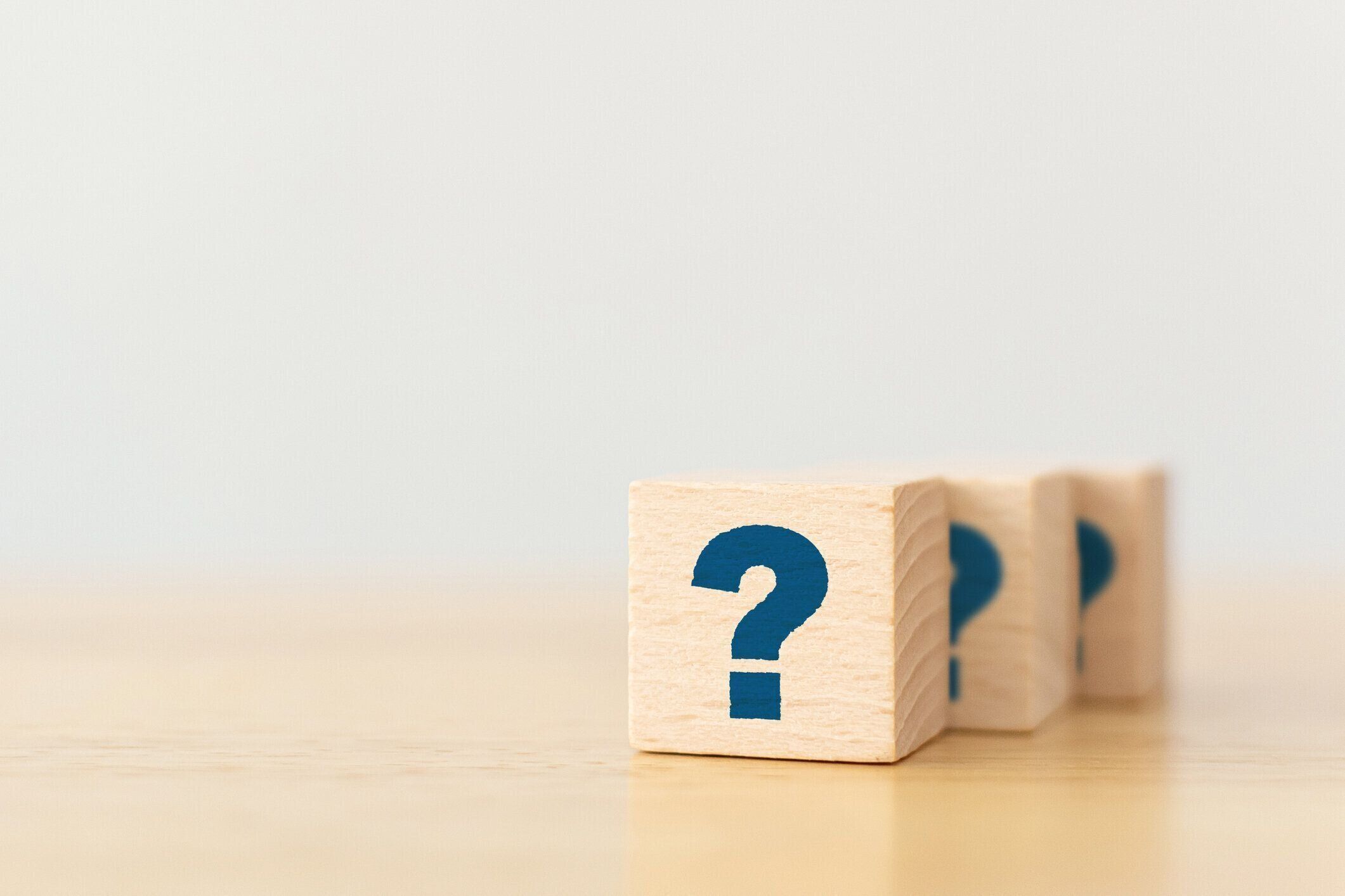 木製のテーブルに記号の疑問符記号が付いている木製の立方体ブロックの形
