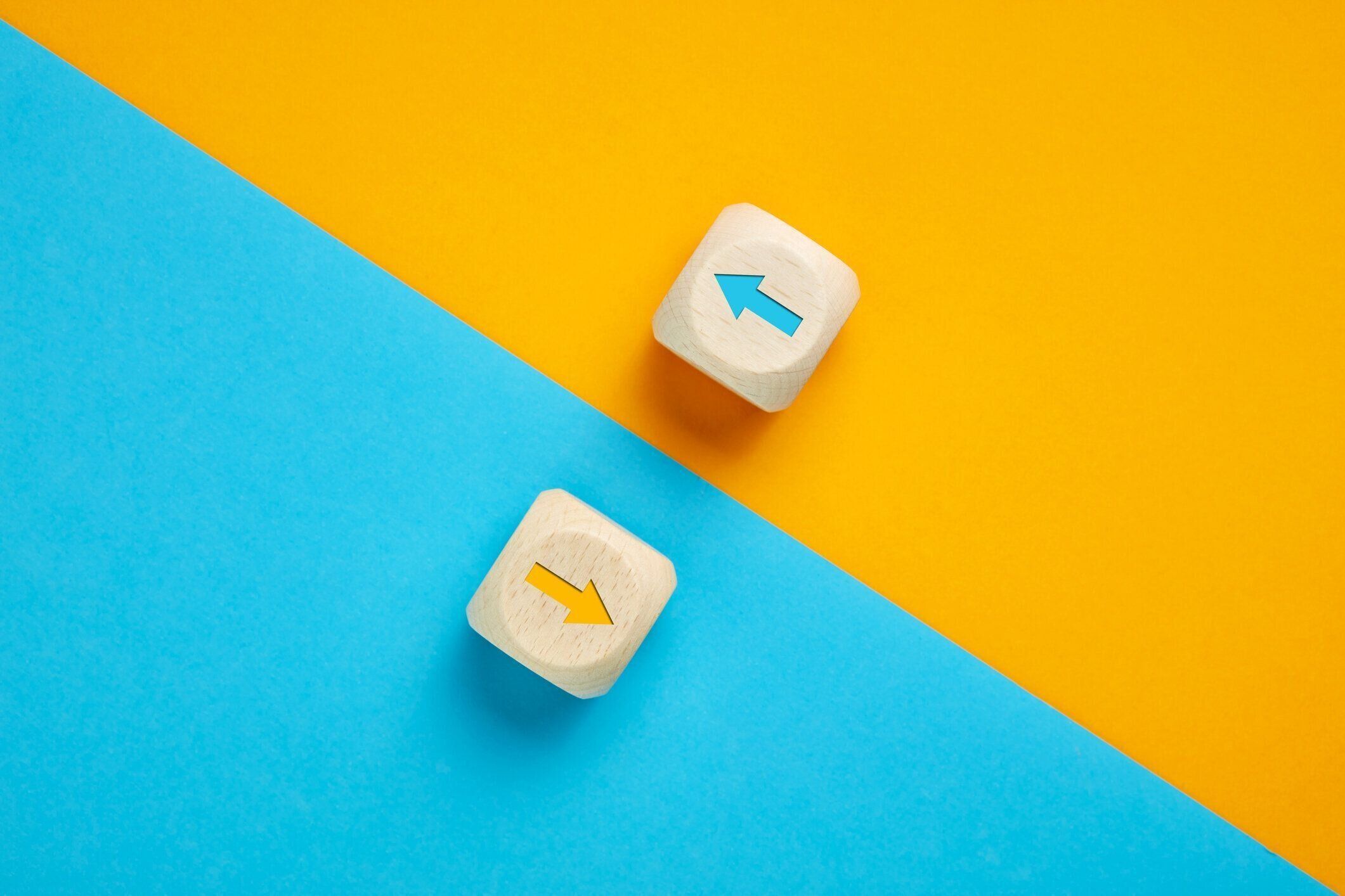 反対方向に向かって移動する木製の立方体の対比の矢印アイコン。競争、多様性、反対または対立の概念。