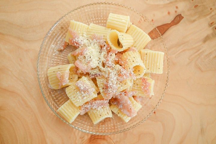 ガラスの皿に盛られた生ハムと粉チーズのサラダパスタ