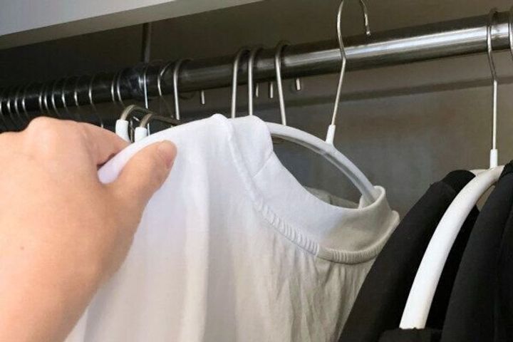 衣類をクローゼットに掛けるシーン