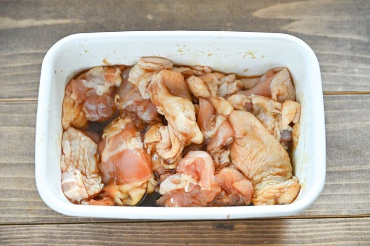 白い琺瑯容器に入った漬け込んだ鶏もも肉