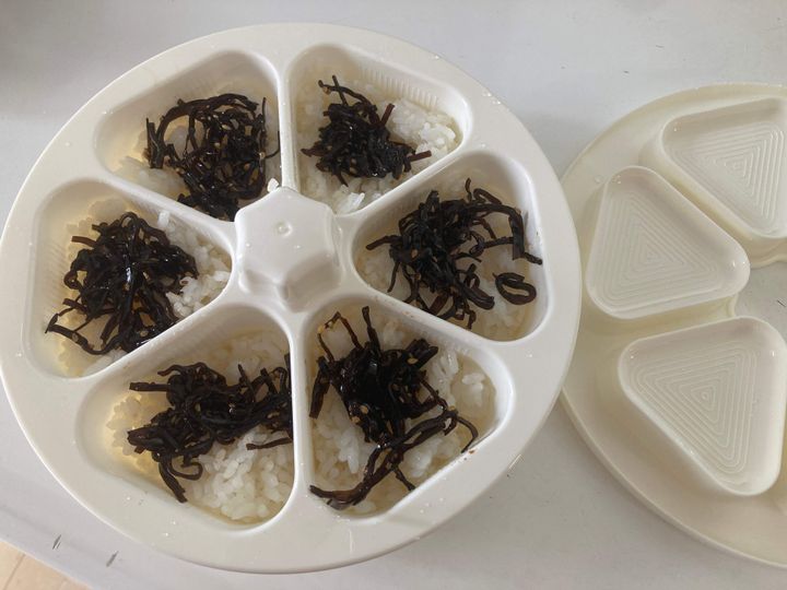 おにぎりメーカーにご飯と昆布を詰めている