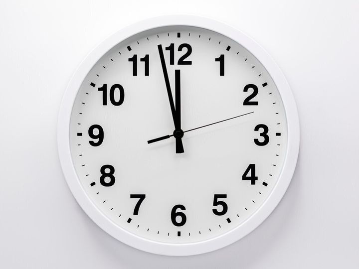白い背景にシンプルなアナログ壁掛け時計。