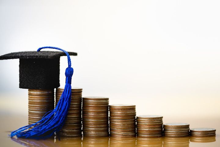 白い背景にコインのお金に卒業帽子。