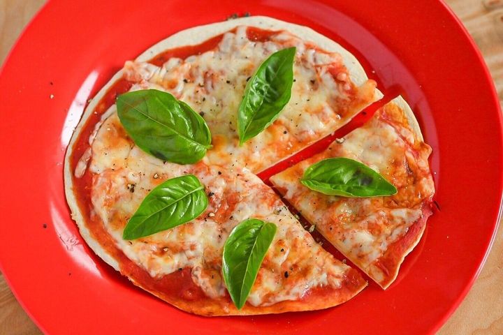 赤い皿にのったトマトピザ