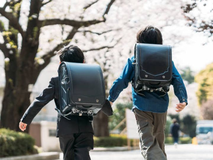 日本の高校生と1年生が交差点で手を挙げる