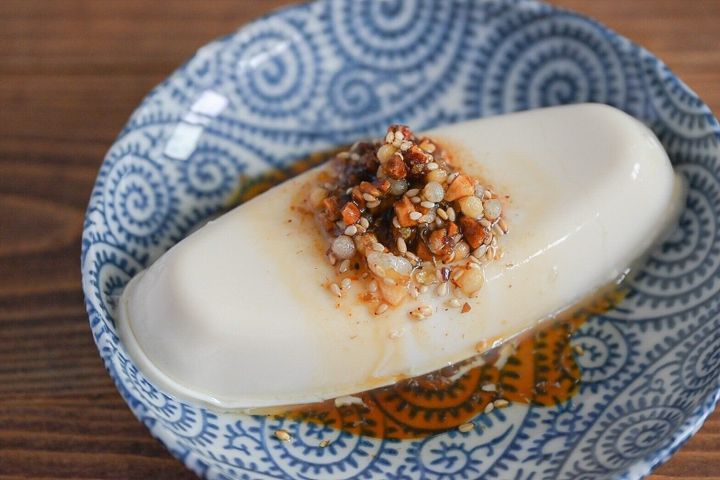 皿に盛られたざくざくたれをかけた豆腐