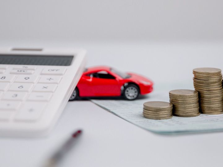 自動車保険事業のコンセプト、新車の税金とローンによる購入販売の節約。背景に車のおもちゃの車とスタックコインのお金。交通金融コストの管理を計画しています。車のローン