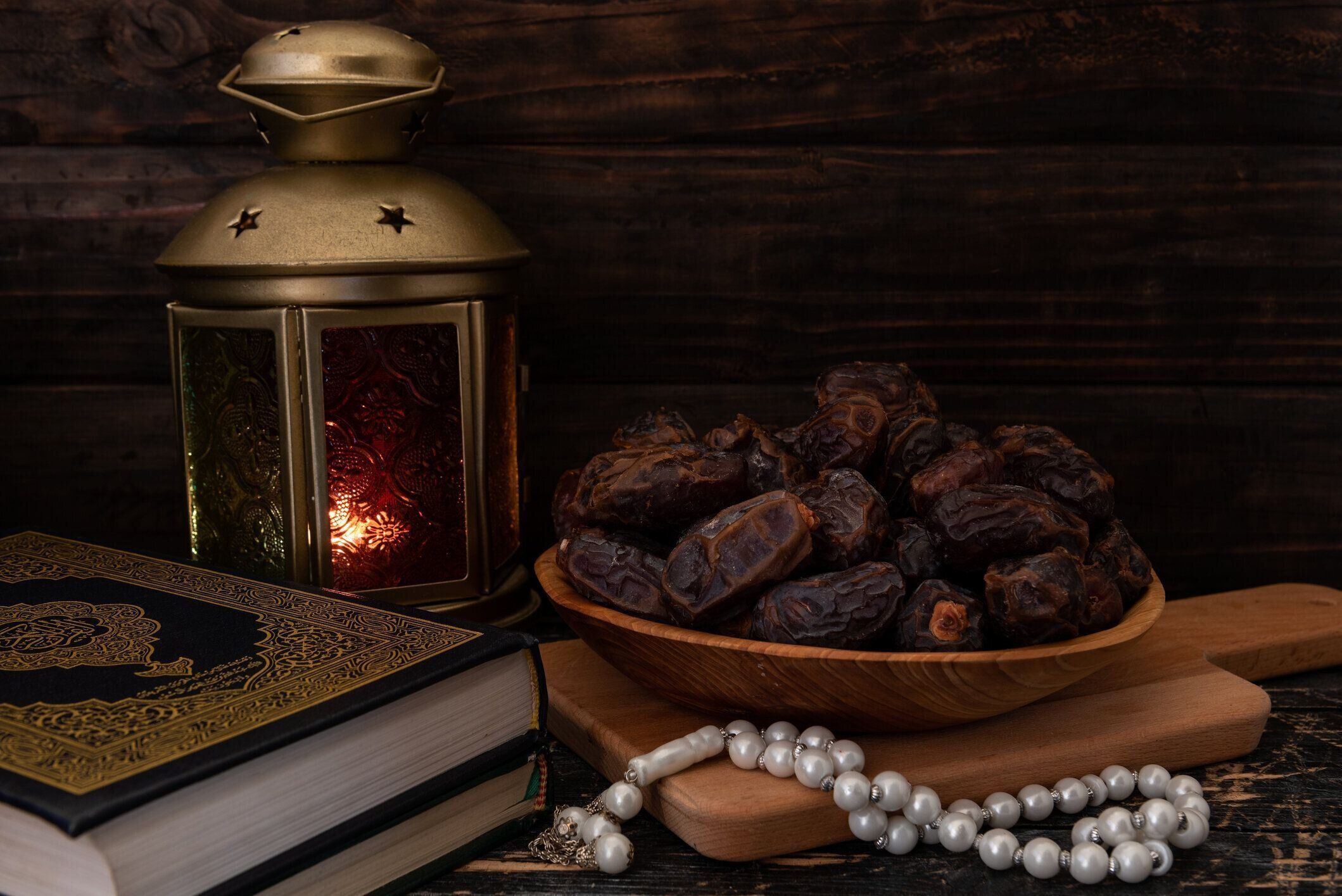 木製の皿、ロザリオビーズ、聖クルアーン、ランタンに入った乾燥ナツメヤシまたはクルマ。