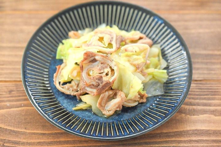 青い皿に盛られた豚なんこつとキャベツのフライパン蒸し