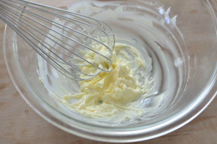 ガラスのボウルに入れたバターを、泡立て器でクリーム状にした様子