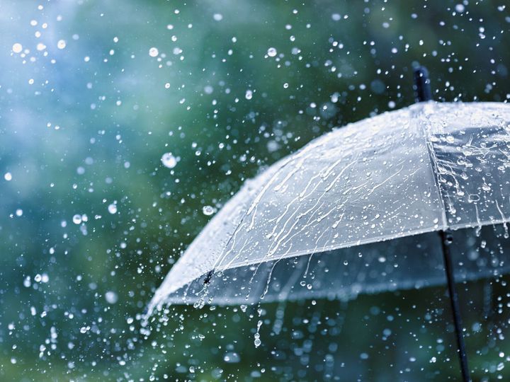 水滴に対する雨の下で透明傘は、背景をスプラッシュドロップ。雨の天気の概念。