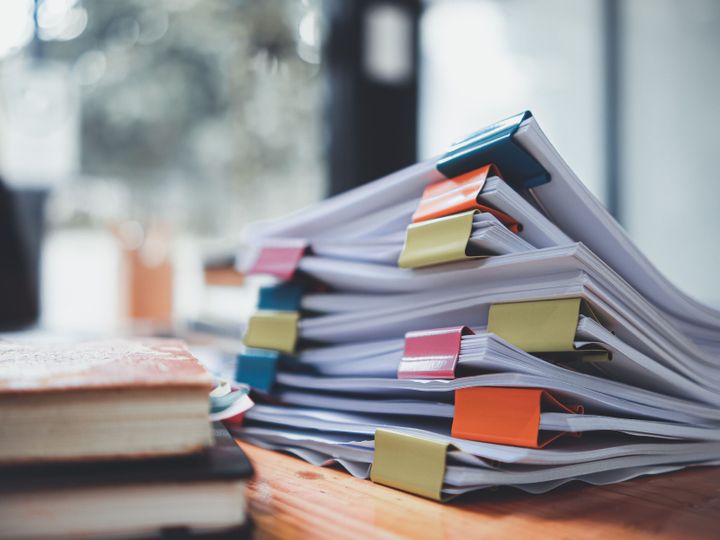 机の上に置かれた書類の山は、ビジネスマンや投資家と会う前に正しい情報を使用するために取締役会に送られる前に検証されるのを待っています。