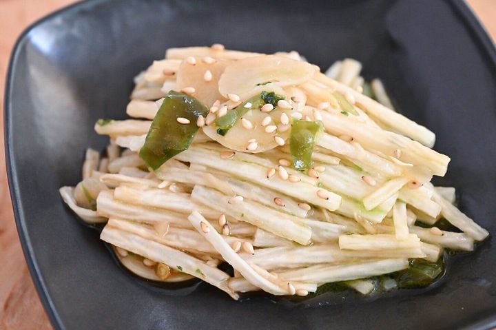 黒い皿に盛られた長芋の青いにんにく辣油和え