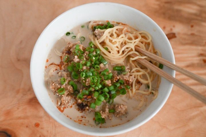 箸で持ち上げたミルク担々ラーメン