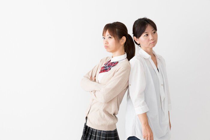 アジアの若い母親と白い背景の上の娘