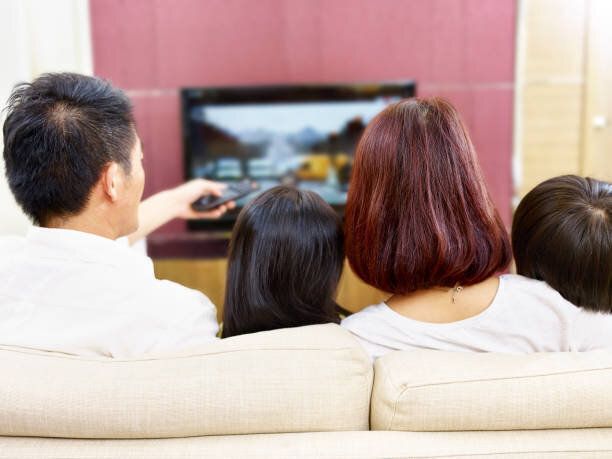 アジア家族一緒にテレビを見て