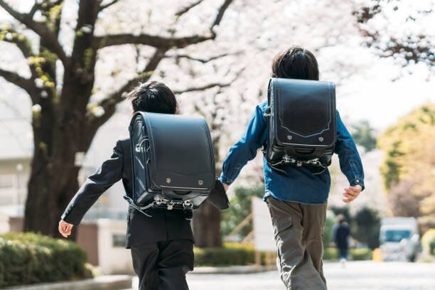 日本の高校生と1年生が交差点で手を挙げる