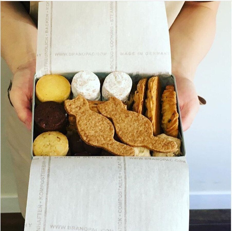 クッキー缶を手に持つスタッフ