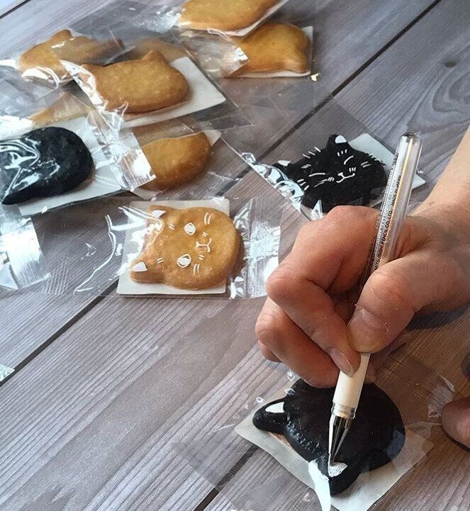 ペンで猫の顔をかく手