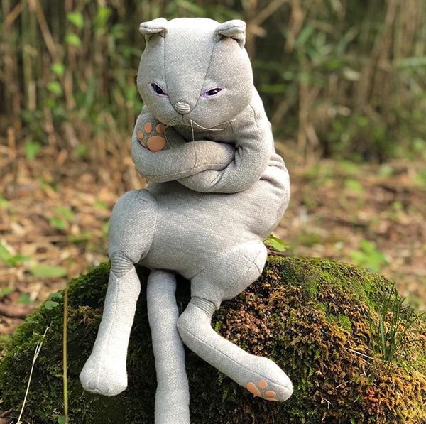 腕組みして座る猫のぬいぐるみ