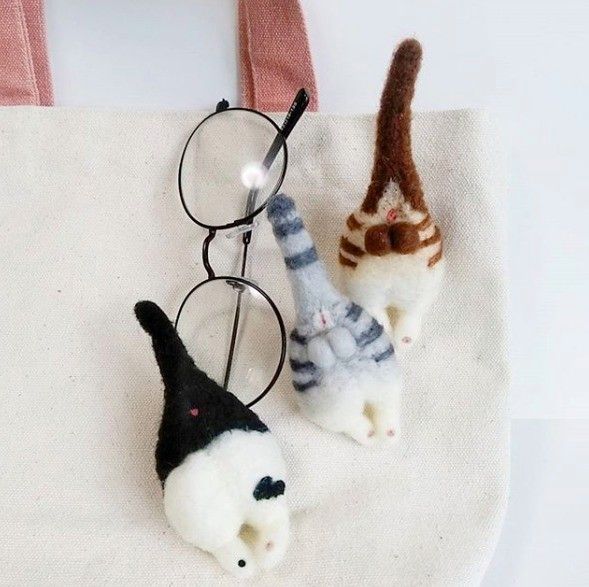 バッグについている茶色・グレー・黒白の猫のお尻ブローチ