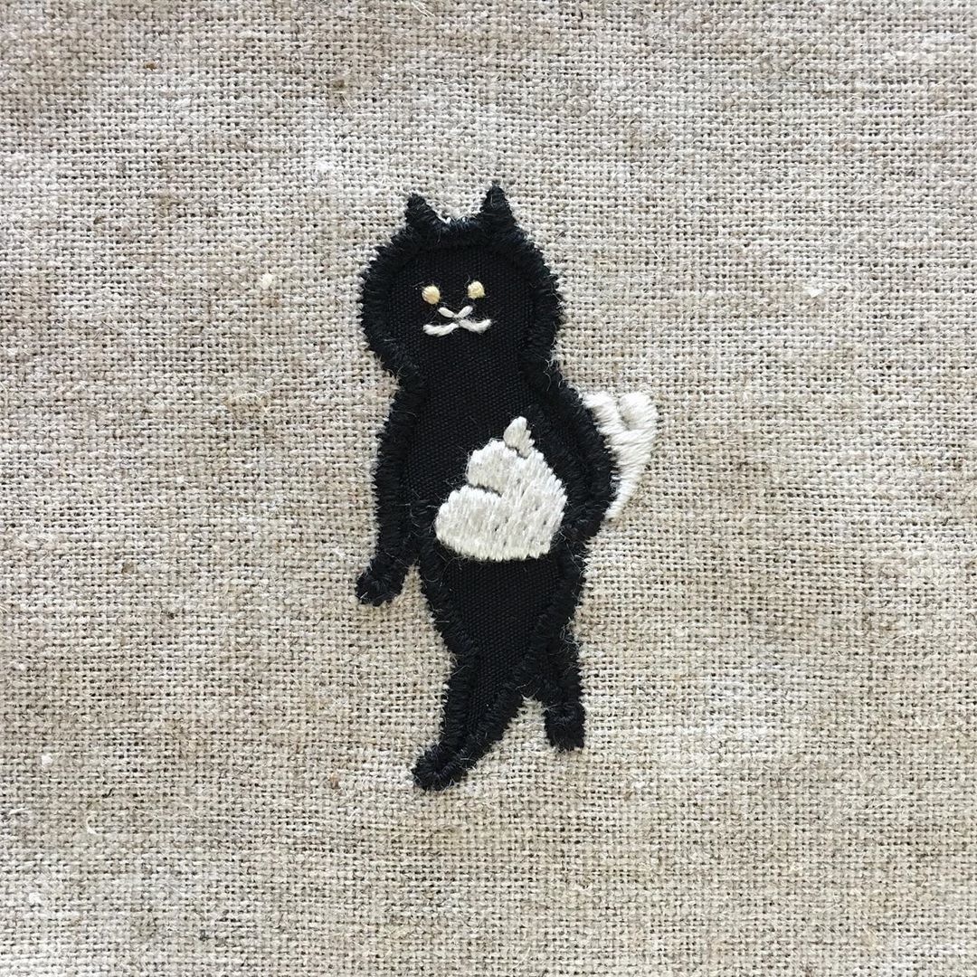 餃子を抱える黒猫の刺繍