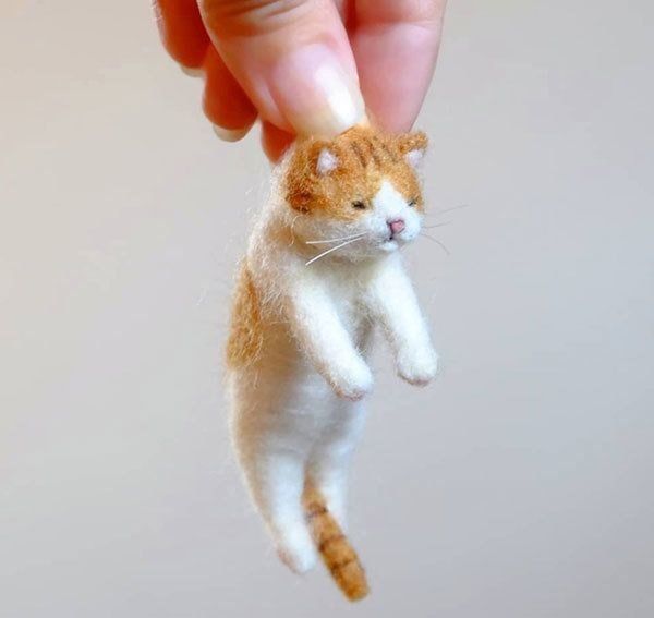 寝起きに首根っこをつままれた猫ストラップ