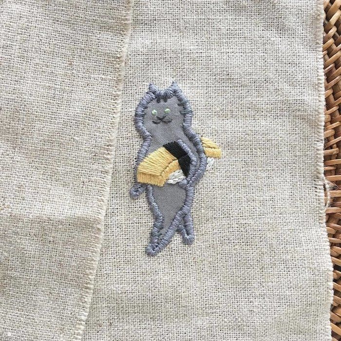 たまごのお寿司を抱えた猫の刺繍