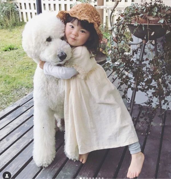 仲良しなスタンダード・プードルと女の子