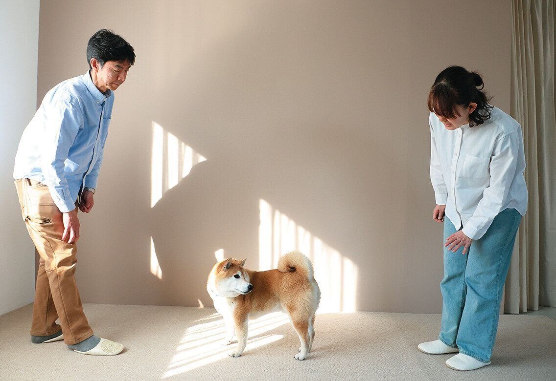 後ろから愛犬に声をかける飼い主